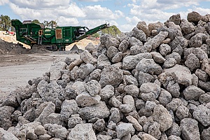 close up view of a pile of rocks with a machine in the background