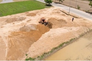 tractor dustributing dirt on ground