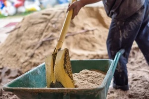 worker loading fill dirt in small cart