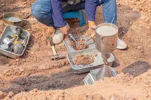 worker using equipment for testing laboratory field density testing construction sand cone method and soil density test of road under the construction