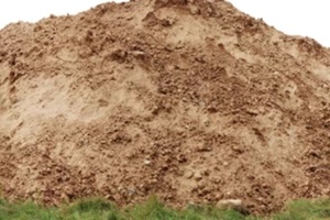 a large pile of construction sand on forest grassy site