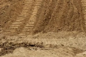isolate mounds of sandy brown soil that have been excavated and poured together with large backhoe wheels