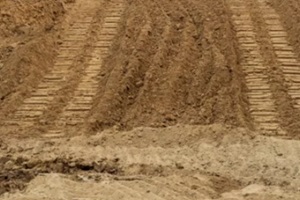 isolate mounds of fill dirtthat have been excavated and poured together with large backhoe wheels to prepare materials for filling in Punta Gorda