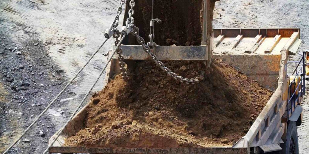 excavator bucket filled with a substantial load of earth and dirt for construction purposes