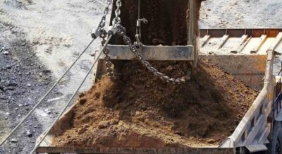 excavator bucket filled with a substantial load of earth and dirt for construction purposes