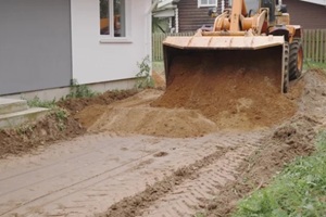 heavy machinery is leveling and preparing the ground at a busy construction site for future projects