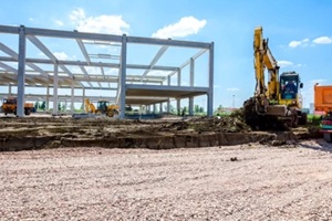 backhoe is loading a truck with ground on building site