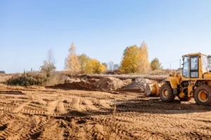 machine distributing sand on a construction site