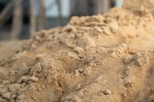 pile of fine sand for building the house that stack on the ground with construction site as blurred background