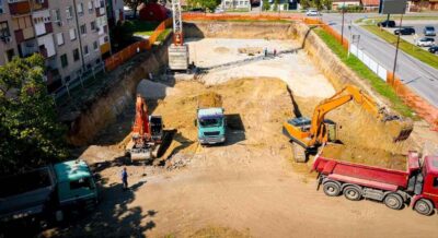 ariel view excavator is loading fill dirt into a truck with ground on building site in central FL