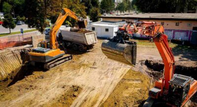 ariel view excavator is loading a truck with fill dirt to on building site in Punta Gorda, FL
